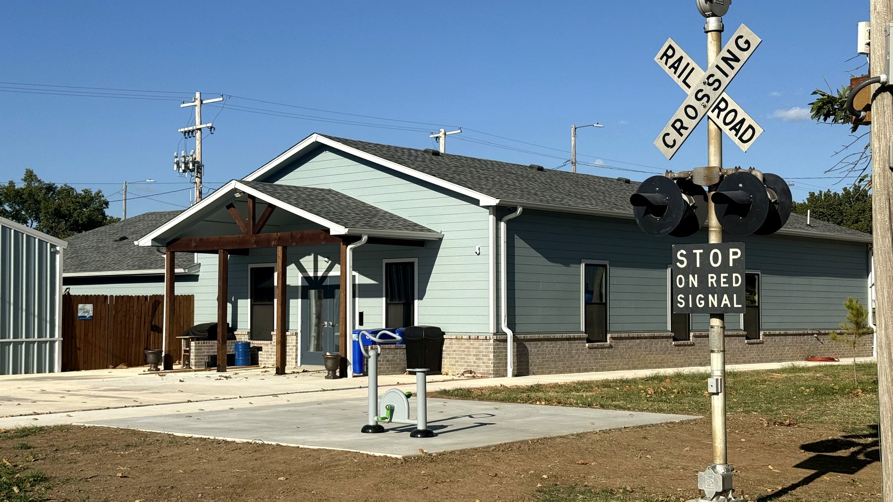 Talala Community Building from Town Park, with the railroad crossing signal in the foreground