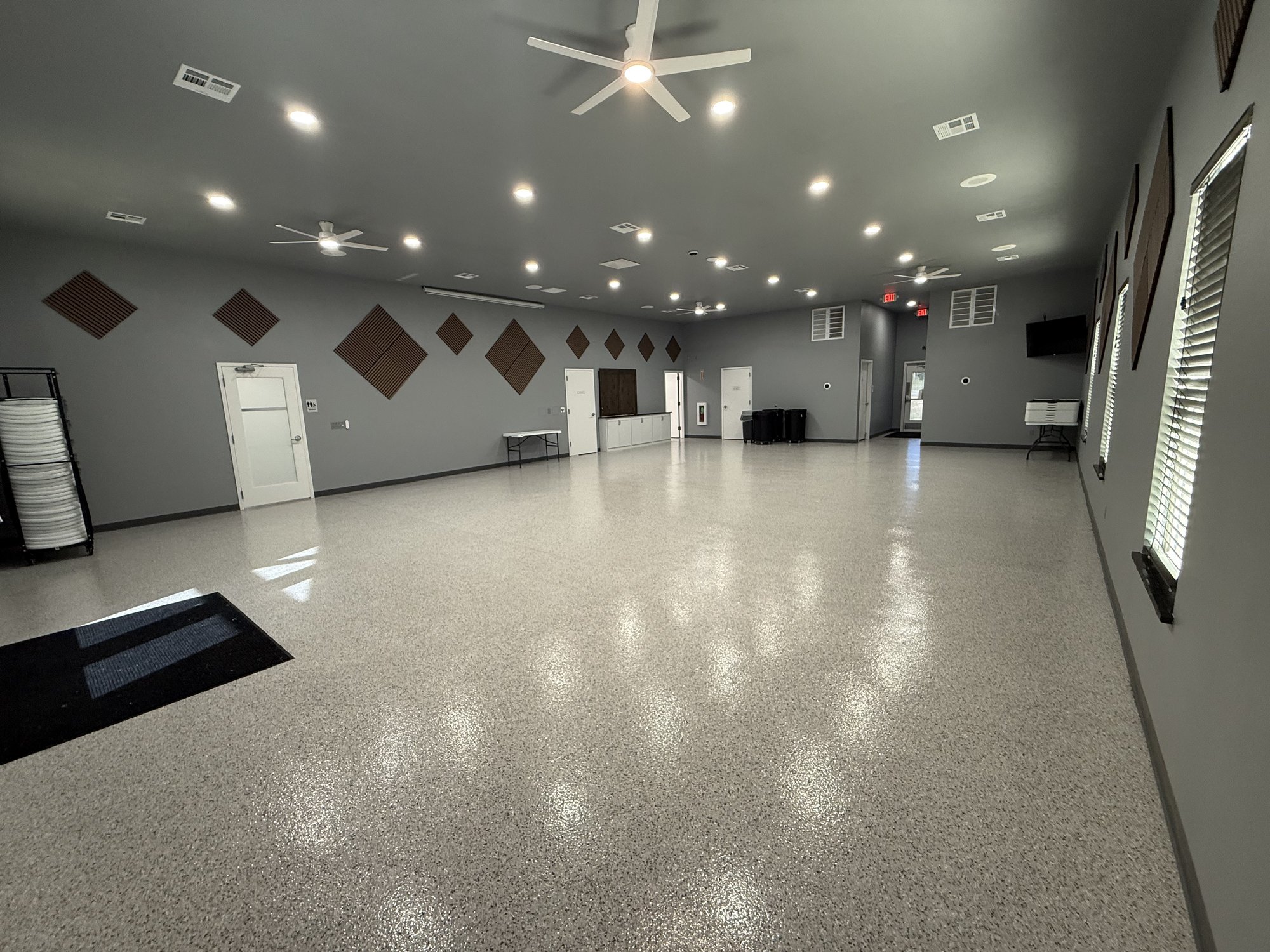 Open main hall of the Talala Community Room with ceiling fans and speckled floor