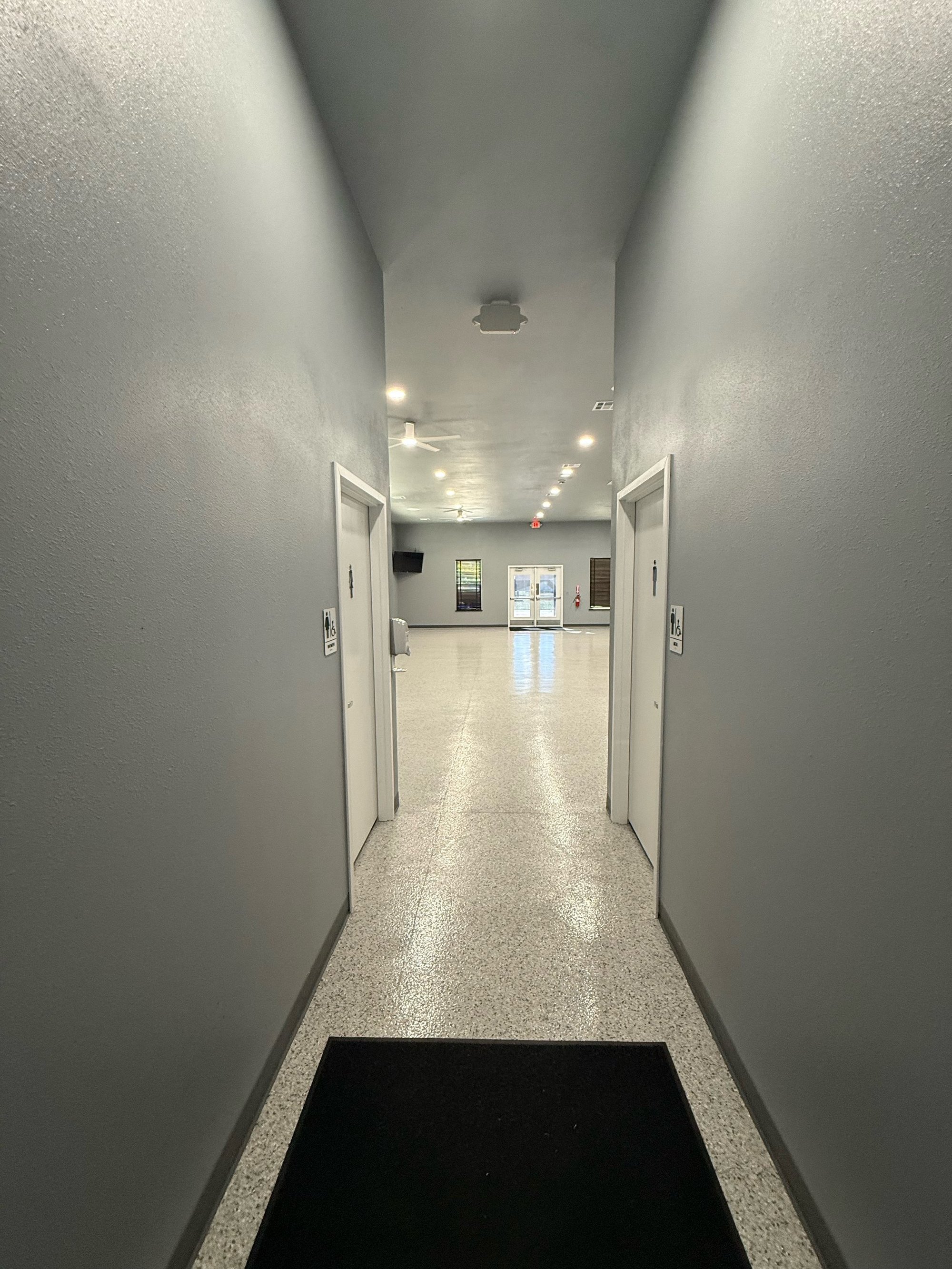 Hallway looking into the Community Room with restroom doors on both sides