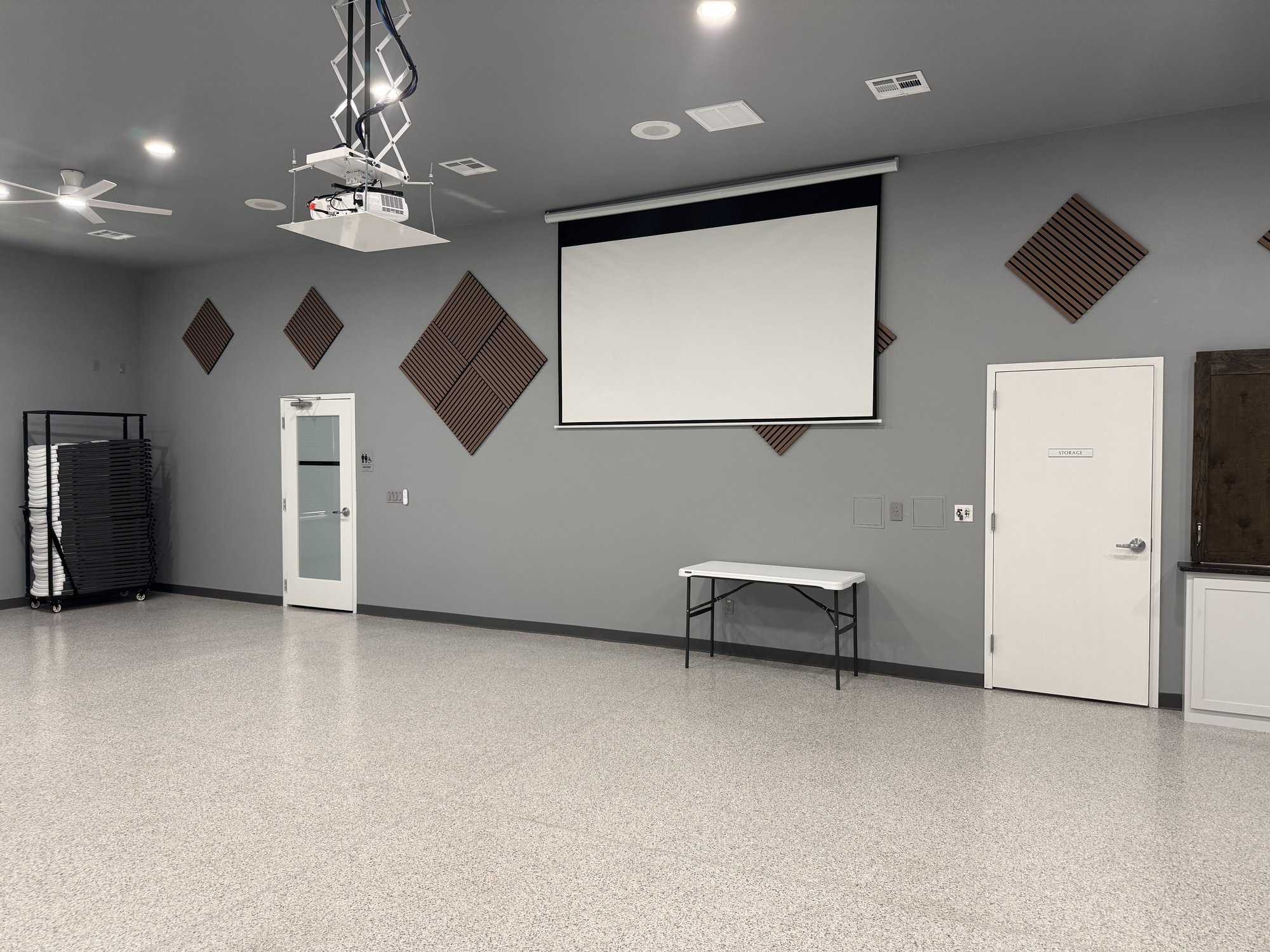 Projector screen and ceiling-mounted projector lift in the Community Room