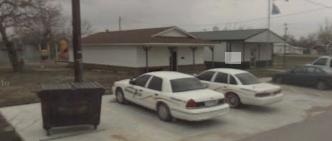 Earlier view of the old Talala municipal buildings with police cars parked in front