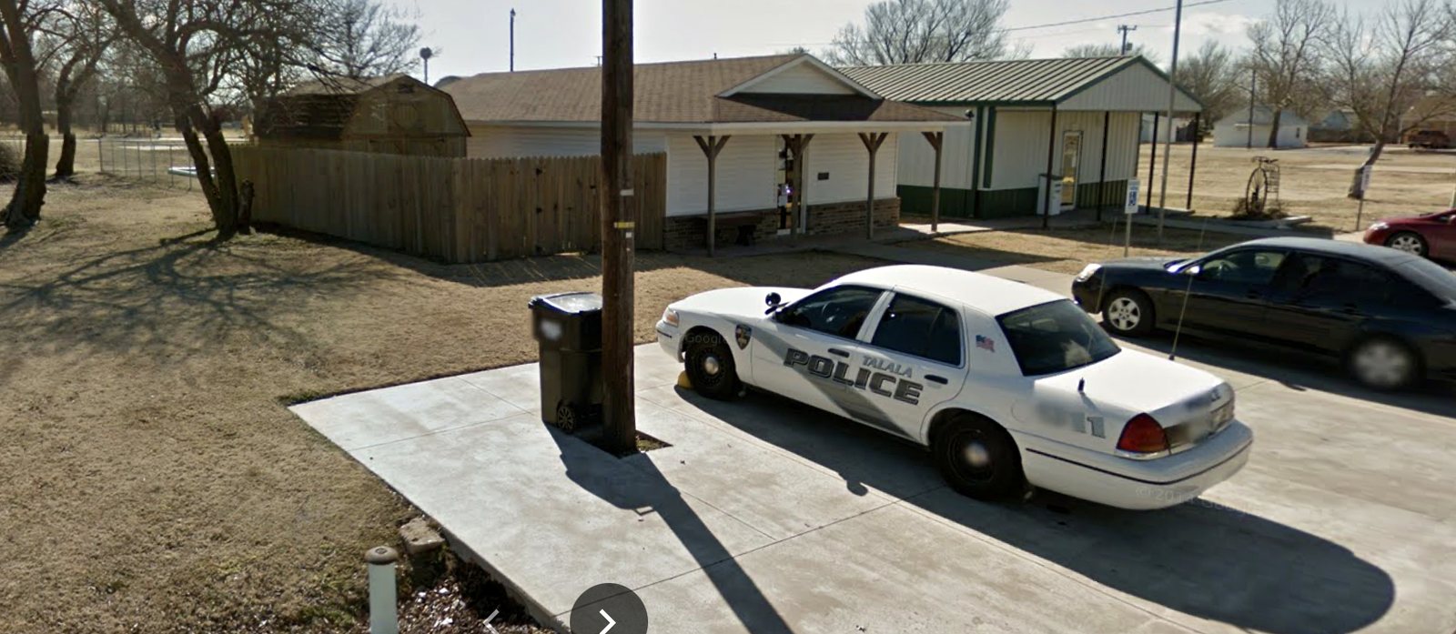 Talala Police Crown Victoria parked in front of the former white Police building